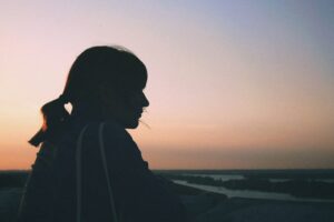 Silhouette of woman against setting sun